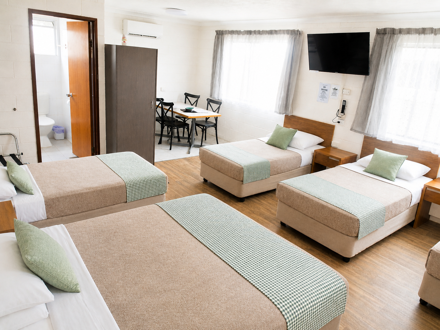 Cozy hotel room with four beds.