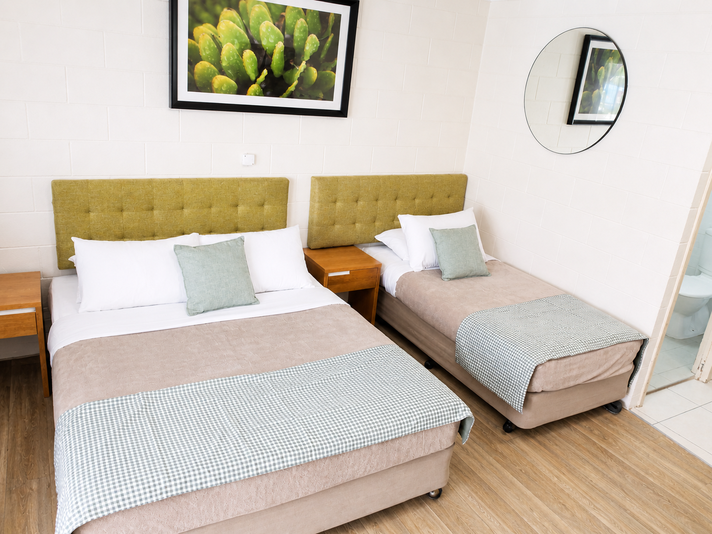 Modern bedroom with double and single beds, stylish decor, and warm lighting.
